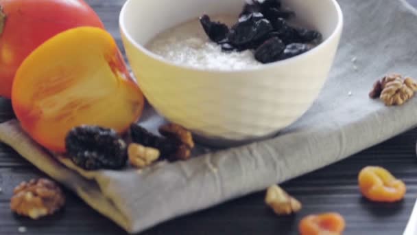 그릇에 오트밀을 식사를 준비하는 오트밀에 자두를 첨가하는 — 비디오