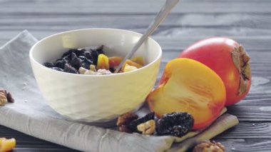 Hurma, kuru kayısı, kuru erik, ceviz ve susamlı kaşık ile birlikte derin bir kasede yulaf ezmesi. Sağlıklı yemek.