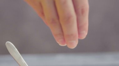 Sağlıklı yiyecekler. Sağlıklı kahvaltı hazırlıyor. Kadın eli yulaf ezmesine susam tohumu ekliyor. Hurma, kurutulmuş kayısı, kuru erik, ceviz.