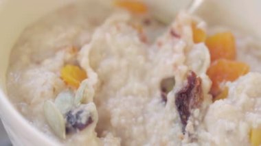 Derin bir kasede kurutulmuş kayısı, kuru erik ve kabak çekirdeği ile yulaf ezmesi. Sağlıklı kahvaltı hazırlıyorum. Sağlıklı yemek.