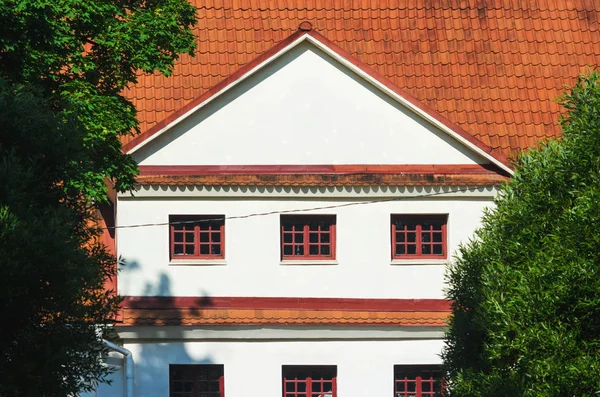 Huis met witte gevel en rode keramische dakpannen — Stockfoto