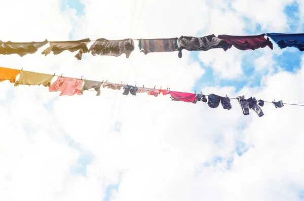 Белье сушится на одежде на фоне голубого неба — стоковое фото