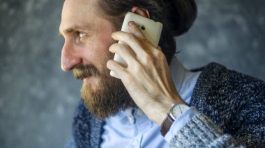 Mutlu Sakallı Adam Telefonda konuşuyor.