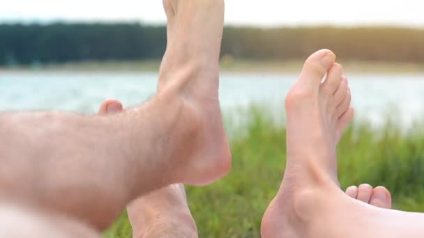 ビーチでリラックスした若いカップルの足の閉じる 女だ男 湖だ風景 脚だぼかしの背景 — ストック動画