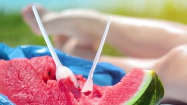 Genç bir kadın sahilde karpuz yiyor. Mutluluk, dinlenme, plaj. Sağlıklı bir yaşam tarzı. Yaz konsepti