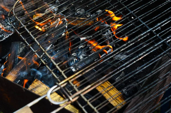 Das Gitter eines Grills wird auf Kohlen warm — Stockfoto