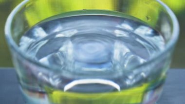 Cam bardaktaki suyun titreşimi. Kapat..