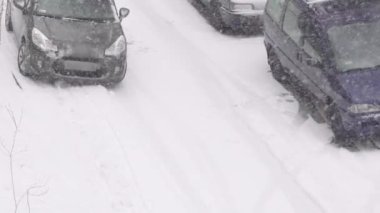 Otoparktaki kar arabaları. Kar fırtınası. Kış gününde kar yağıyor. Şehir kış arkaplanı