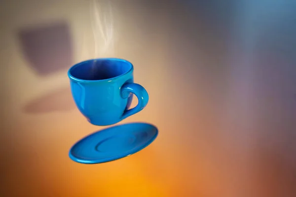 Blue cup of espresso soaring in the air