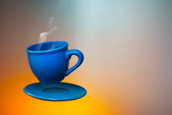 Blue cup of espresso soaring in the air