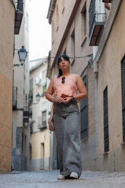 Dar bir Avrupa caddesini keşfeden genç kadın turist,