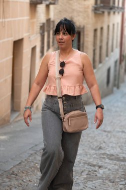 Tarihi bir şehir caddesinde yürüyen bir kadın yaz seyahati sırasında şehir mimarisini keşfediyor.