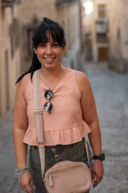 Gülümseyen kadın, tarihi bir geçidi keşfederken tatilin tadını çıkarıyor.