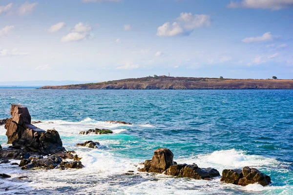 rocks at the black sea shore in summer. waves crashing coast of bulgaria on a sunny morning. cloudless blue sky. travel background at the seaside