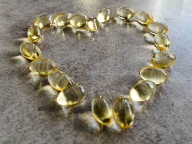 Dev bir kalbe yerleştirilmiş D3 vitamini kapsülleri.