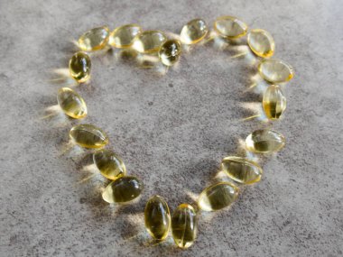 Dev bir kalbe yerleştirilmiş D3 vitamini kapsülleri.