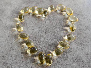 Dev bir kalbe yerleştirilmiş D3 vitamini kapsülleri.