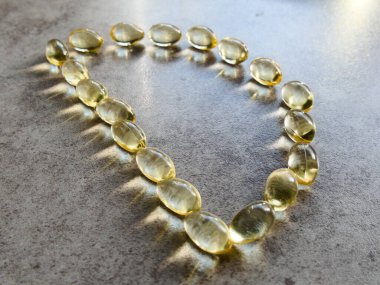 D şeklinde dizilmiş D3 vitamini kapsülleri