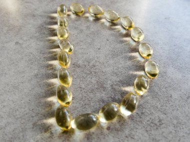 D şeklinde dizilmiş D3 vitamini kapsülleri