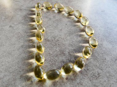 D şeklinde dizilmiş D3 vitamini kapsülleri