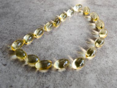 D şeklinde dizilmiş D3 vitamini kapsülleri