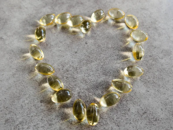 Dev bir kalbe yerleştirilmiş D3 vitamini kapsülleri.