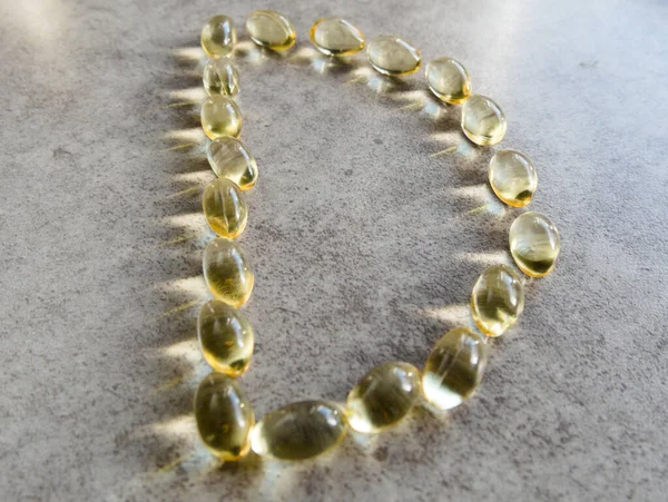 D şeklinde dizilmiş D3 vitamini kapsülleri