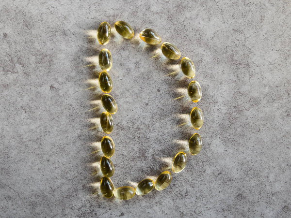 Vitamin D3 capsules arranged in a "D"