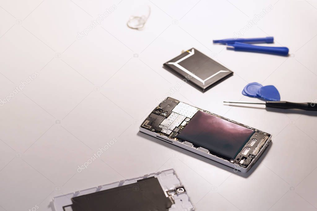 To open smartphone's backside cover to replace a swollen batter. Smartphone repair Concept, (Toned image)