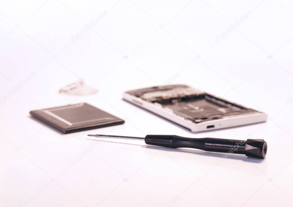 Screwdriver and opened smartphone's backside cover with a new battery. (Smartphone repair Concept, Toned image)