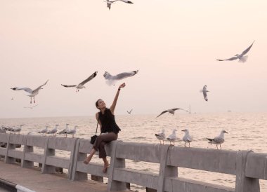 Samut Prakan, Tayland - 14 Kasım 2018: Genç kadın Bang Pu deniz, gün batımında kuşlar beslemeleri-birçok göçmen kuşların canlı bu nedenle orada olur turistik