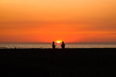 iki adam konuşurken günbatımı anda silüeti