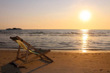 Plaj sandalyesini günbatımı zamanı tropikal plaj