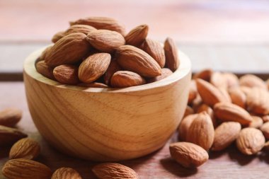 Rustik arka plan üzerinde ahşap kase badem fındık.