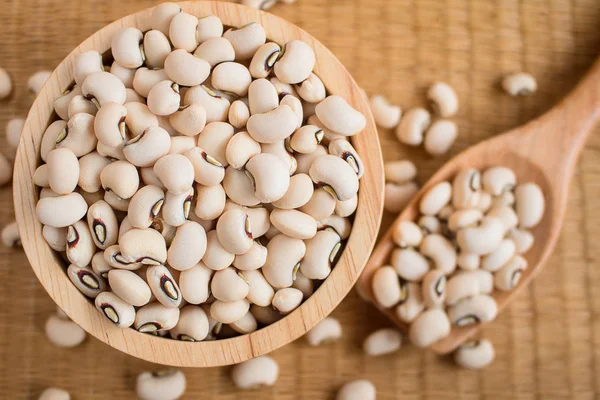 Black Eyed Beans i träskål på vass matta. — Stockfoto
