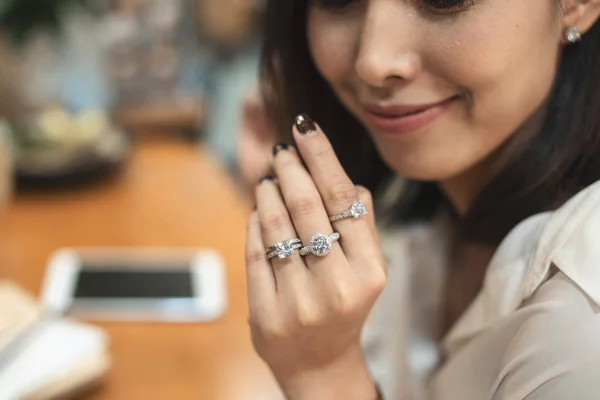 Primer plano de un elegante anillo de diamantes de compromiso en el dedo de la mujer con suéter de color rosa oscuro ropa de invierno. concepto de amor y boda . — Foto de Stock