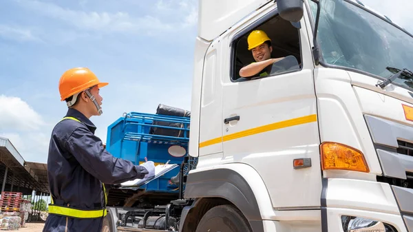 Foreman com chapéus de segurança e colete de segurança está carregando um carro . — Fotografia de Stock