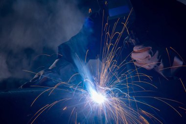 Industria üzerinde profesyonel kaynakçı ve maske kaynak metal boru