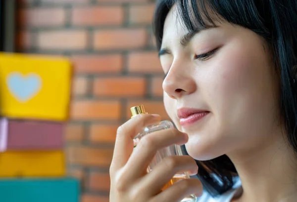 Asijská žena s malou lahví a vonící parfémy. — Stock fotografie