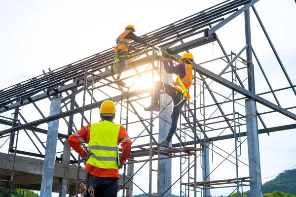 Techniker beobachtet Team von Arbeitern auf hoher Stahlplatte — Stockfoto