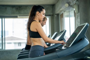 Spor salonunda makine kullanan bir grup genç..