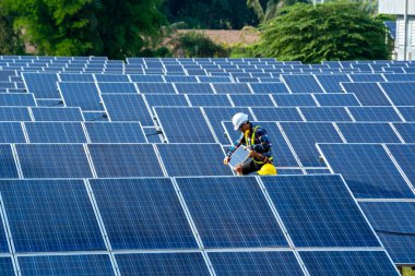 Güneş enerjisi santralindeki ekipmanları, iklim değişikliğini ve yenilenebilir enerji kavramını kontrol etmeye çalışan mühendis.