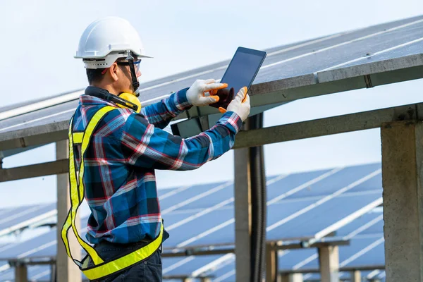 Güneş enerjisi santralindeki ekipmanları, iklim değişikliğini ve yenilenebilir enerji kavramını kontrol etmeye çalışan mühendis.