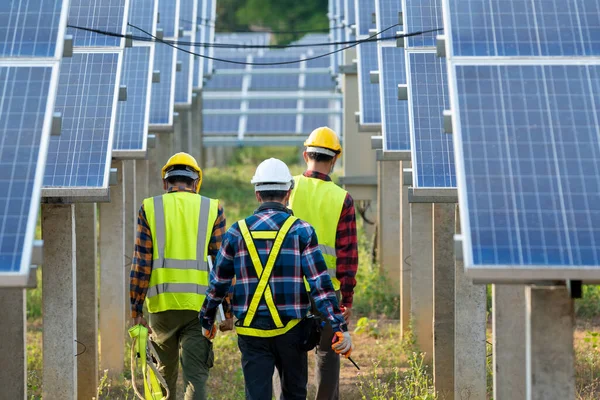 Güneş enerjisi santralinde çalışan ve kontrol eden sağlık maskesi takan bir mühendis, güneş enerjisi panelleri, yenilenebilir enerji dostu yönetim sistemleri kavramı.