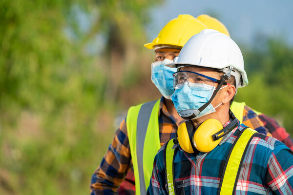 Solar power plant,Electrician wearing a medicine healthcare mask working and checking solar plant at solar power station,Climate change and renewable energy.