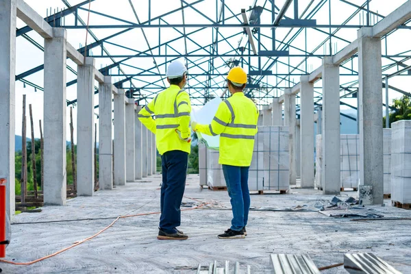 Zwei Ingenieure Harthüten Mit Klemmbrett Und Bauplan Arbeiten Auf Der — Stockfoto