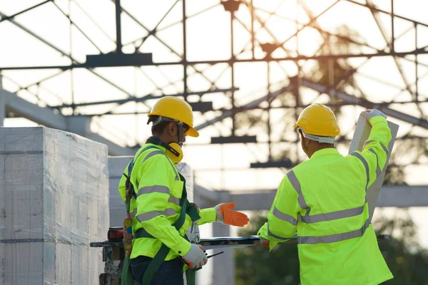 Dois Engenheiros Hardhats Com Prancheta Planta Trabalhando Canteiro Obras Construção — Fotografia de Stock