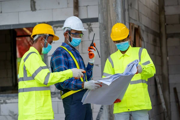 Engineer wearing protective mask to Protect Against Covid-19 and checking production process at the construction site,Engineer,Construction concept,Coronavirus has turned into a global emergency.