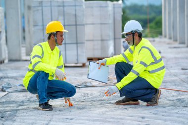 İnşaat mühendisi ekibiyle birlikte inşaat alanında pano kontrolü yapıyorlar..