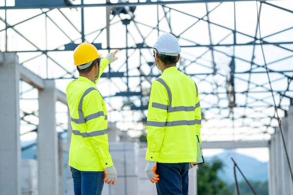 身穿绿色工作服的结构工程师和建筑师正在建筑工地进行建筑工程 — 图库照片